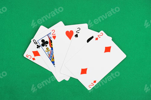 Preview: top view of green poker table with unfolded playing cards combination with different suits