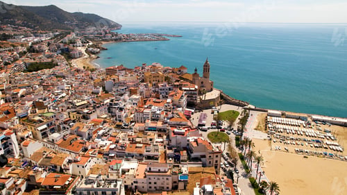 Preview: Aerial view of Sitges coastal village and Iglesia de San Bartolomé y Santa Tecla during a sunny day