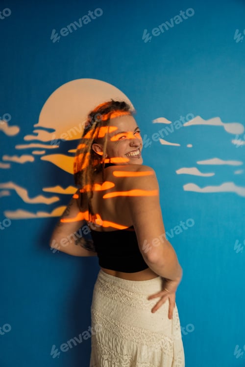 Preview: Woman smiling with dreadlocks against blue mural