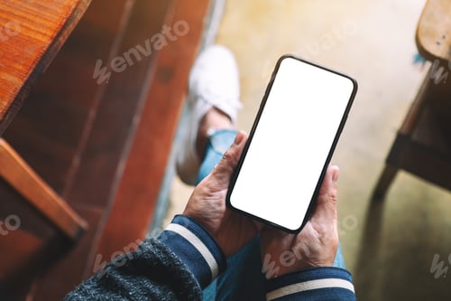 Preview: Top view mockup image of hands holding black mobile phone with blank desktop screen