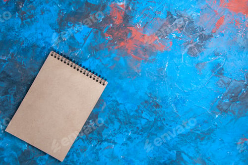 Preview: top view a notebook on blue red background free space