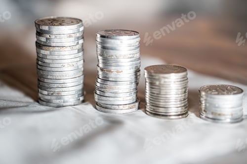 Preview: Stacks of Silver Coins on White Surface