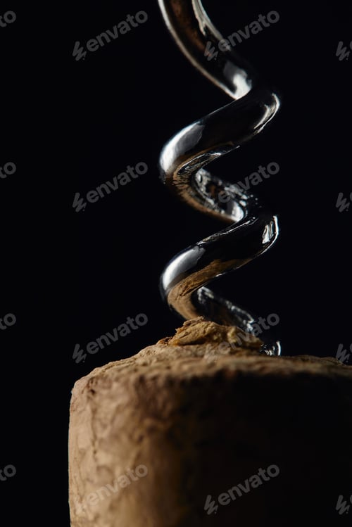 Preview: Close up view of wooden cork and corkscrew isolated on black