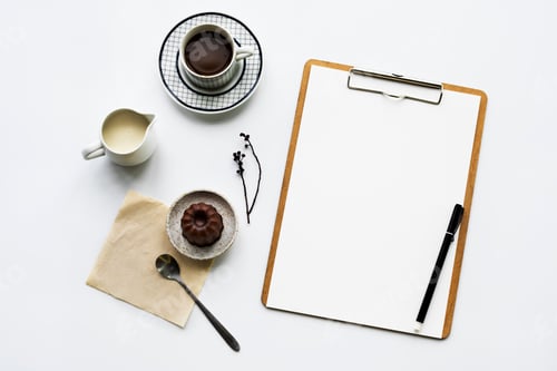 Preview: Aerial view of paper clipboard with coffee cup and cake