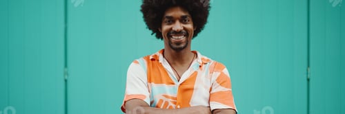 Preview: man wearing shirt smiling at the camera against light blue wall background. Lifestyle concept.