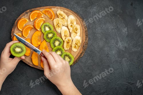 Preview: Overhead view of natural organic fresh fruit set on cutting board on the right side on dark