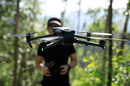 Preview: People remote control a flying drone in summer forest