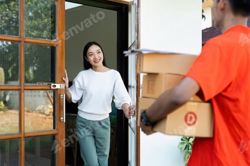 Preview: Young Asian cute girl receiving boxes from postman at the door. Delivery concept