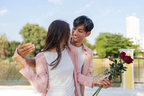 Preview: Romantic valentine surprise outdoor park couple holding roses bright day intimate moment for love