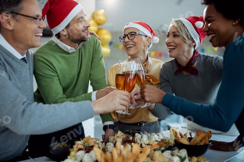 Preview: Happy business people celebrating and toasting with Champagne on Christmas party.