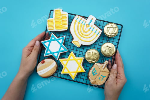 Preview: Women's hands hold a lattice with gingerbread symbols of Hanukkah