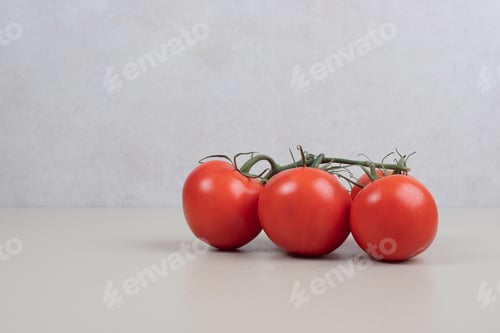 Vorschau: Bündel frischer, roter Tomaten mit grünen Stielen auf weißem Hintergrund