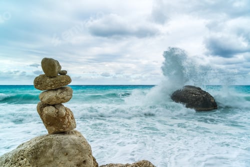 Preview: A balanced pile of stones in front of the waves