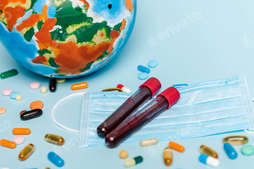Preview: test tubes with blood samples near medical mask, pills and globe on blue background, coronavirus