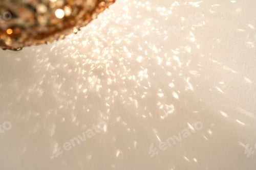 Preview: Reflections of a golden Christmas ball on a white background.