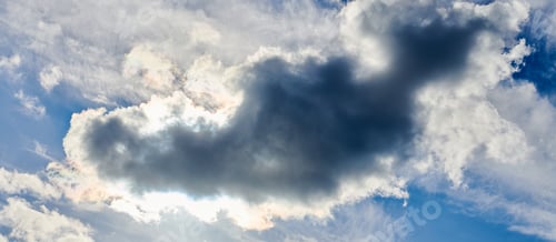 Dramatic Clouds with Sun Shining Through Blue Sky