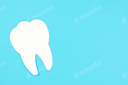 Preview: Big white tooth on a blue background. Dental care concept, copy space