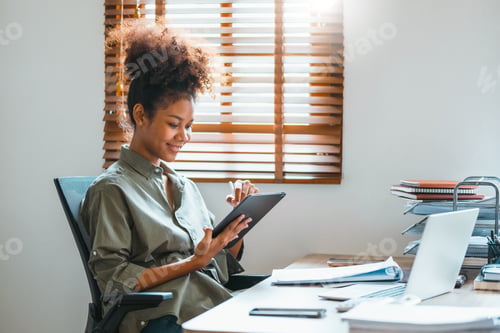 Preview: Happy African American teenage woman using a digital tablet and Laptop.