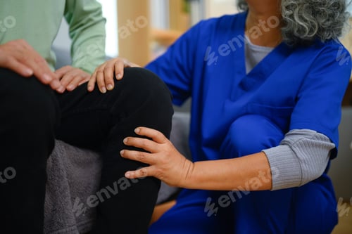 Preview: Female physiotherapist giving leg massage to senior man at home. Healthcare concept