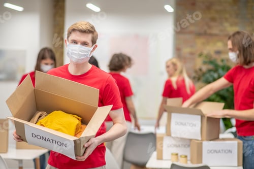 Preview: Volunteers in facial masks working with donations sorting