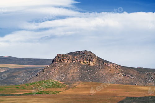 Preview: View of large stone cliff and farm fields