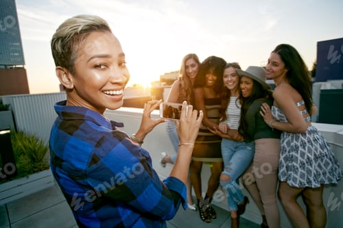 Preview: A group of young women partying on a city rooftop at dusk