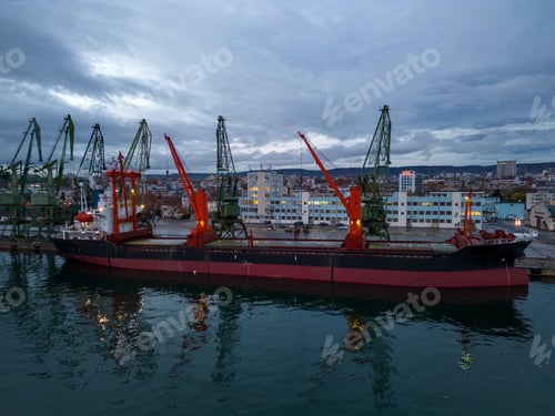 Preview: Aerial view of cargo ship bulk carrier is loaded in port at sunset