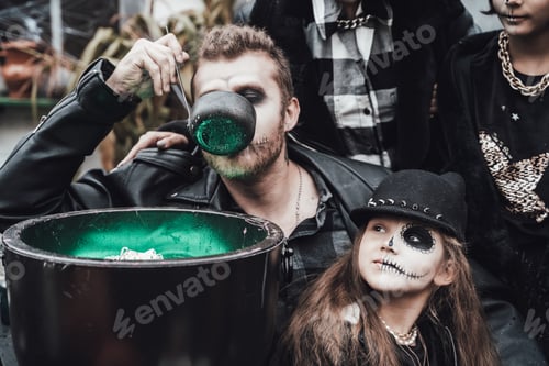 Preview: Scary family, mother, father, daughters celebrating halloween. Cauldron of potion.Terrifying black s
