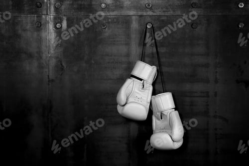 Preview: White leather boxing gloves hanging on black wall