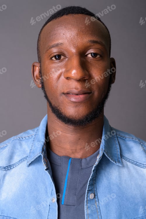Preview: Young handsome African man with short hair against gray backgrou