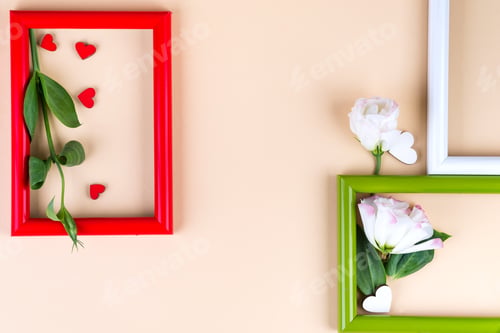 Preview: Empty color frames, red hearts and flowers eustoma on beige paper background with copy space. Love