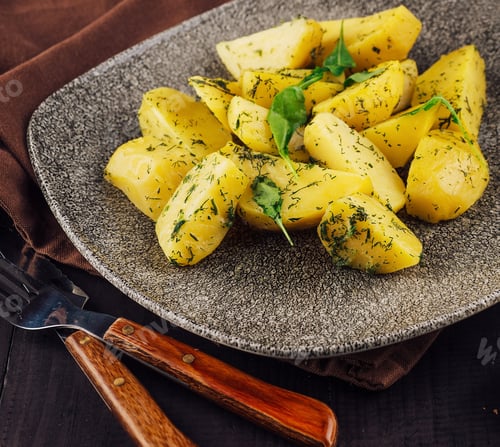 Preview: Delicious baked potato wedges with dill and herbs on gray plate