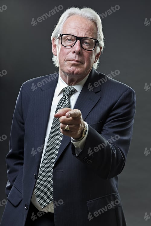 Preview: Studio Portrait Of Senior Business Man With Glasses Looking Tough.