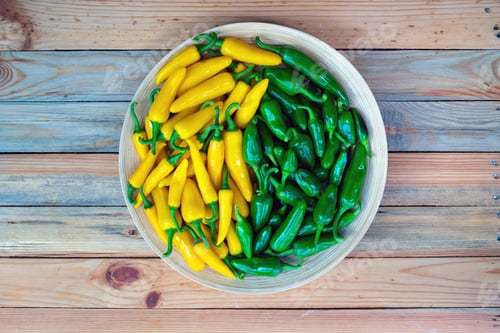Preview: Yellow hot peppers on wooden plate
