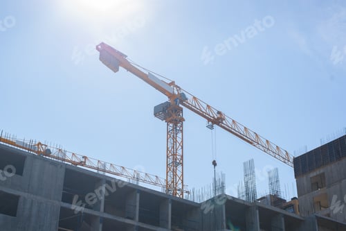 Preview: Construction crane on a background of clear blue sky. Concrete structure of the building. Outdoor