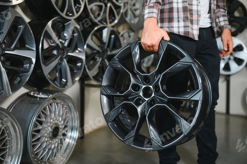 Preview: male customer choosing alloy wheel rims at car repair service or auto store