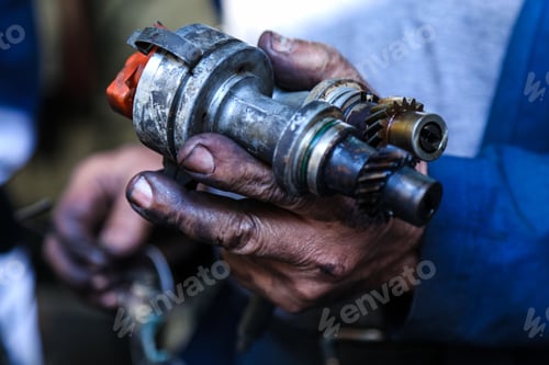 Preview: Closeup shot of mechanician hands holding two ignition distributor with blur background