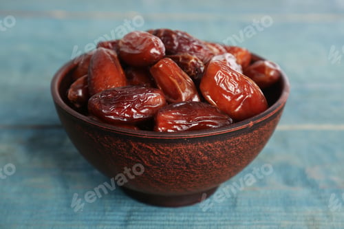 Preview: Sweet dried dates in bowl on light blue wooden table