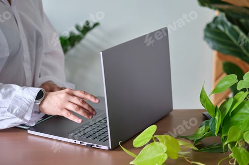 Preview: Women's hands at a laptop against a background of greenery.