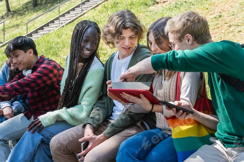 Preview: Group of students collaborating on a project using a tablet outdoors