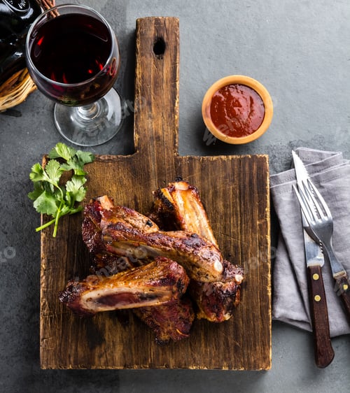 Preview: Pork ribs on cutting board with chili sauce and wine