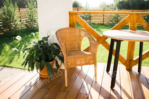 Preview: Cozy wooden terrace of country house or cottage with garden view - table and chair for relaxing