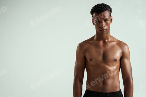 Preview: Strong and confident. Portrait of young shirtless muscular african man looking at camera while
