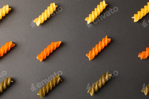 Preview: Flat lay composition with multicolored pasta on black background, space for text and closeup