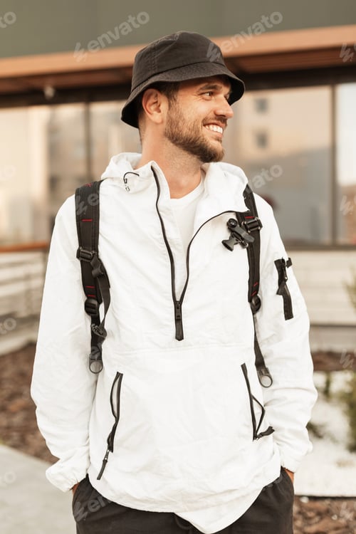 Preview: Handsome fashionable hipster man in stylish summer clothes in the city. Travel