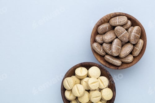 Preview: Alternative medicine tablets on a wooden spoon.