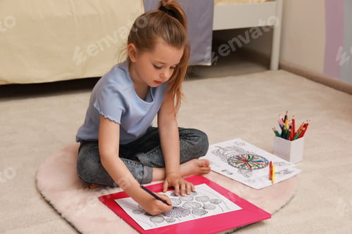 Preview: Little girl coloring antistress page on floor indoors
