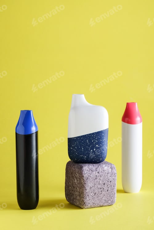 Preview: disposable electronic cigarettes or vapes on yellow background. copy space. nicotine vapor stick.