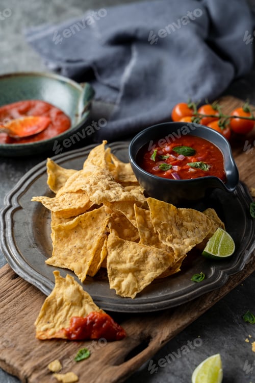 Preview: Traditional Mexican appetizers of hot crispy nachos with tomato salsa sauce dip.