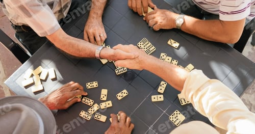 Preview: Senior Friends Shaking Hands Winning Game Of Domino